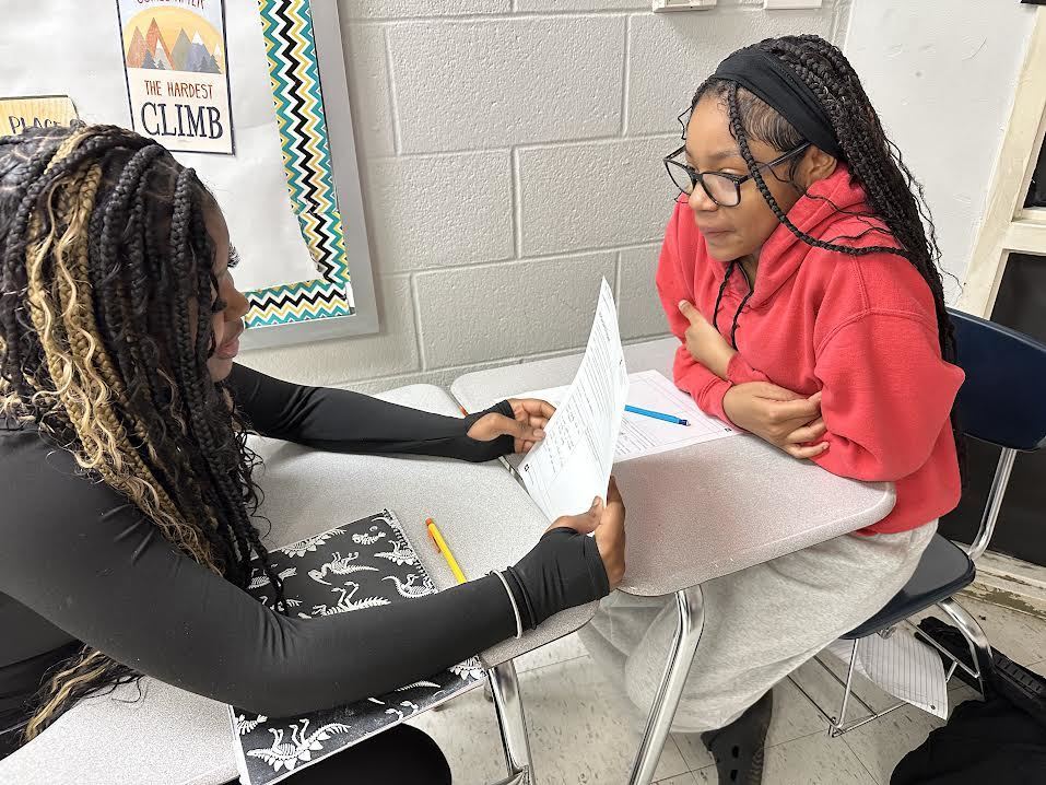 Two students talking with each other about a class project.