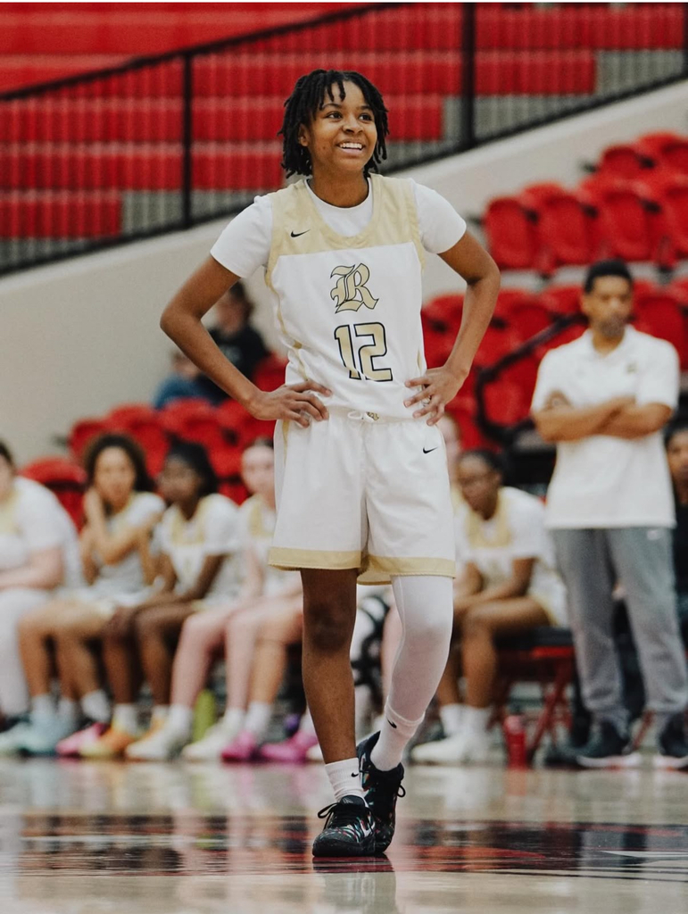 Smiling Lady Senator basketball player standing on the court with hands on her hips 