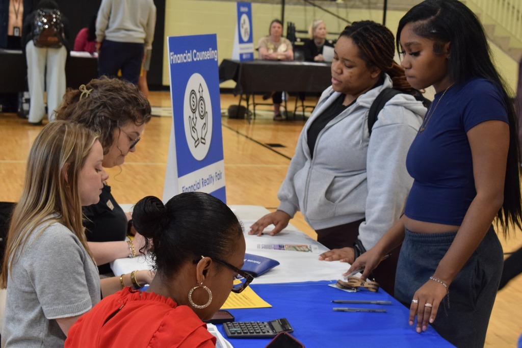 Students having a discussion about financial counseling while budgeting at a table.