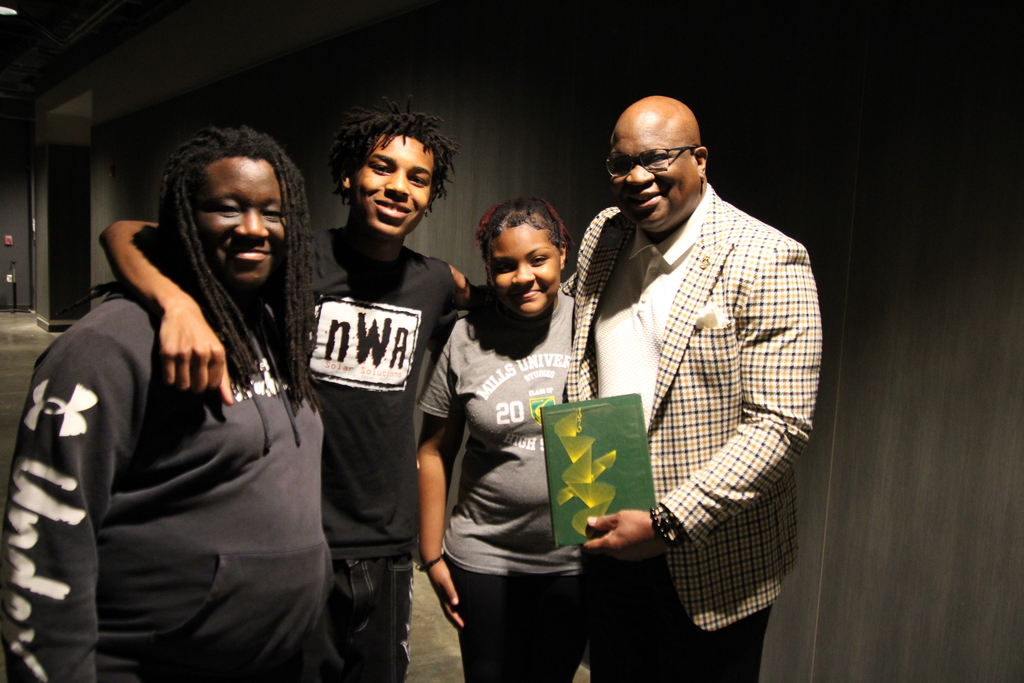 Three kids and one adult posing together for a photo