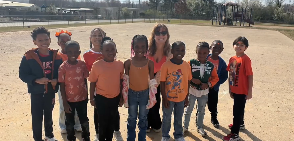 Group photo outside of several students and their teacher outside