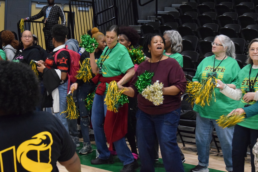 People enjoying music and pom poms.