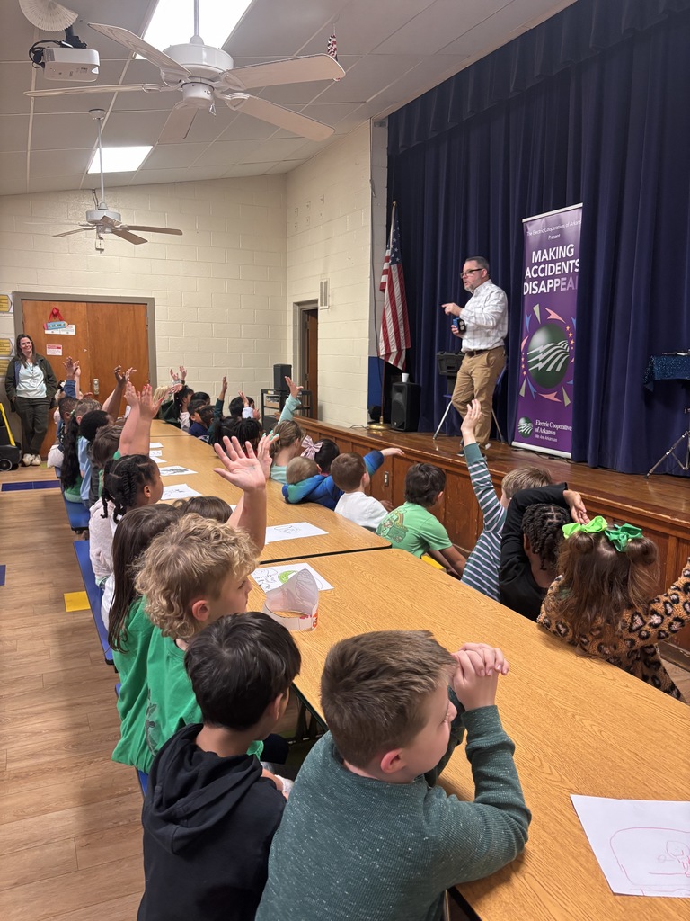 Scott Davis in front our Lawson Students explaining what his show is all about (electrical safety). He is on stage with a banner behind him that reads "making accidents disappear".