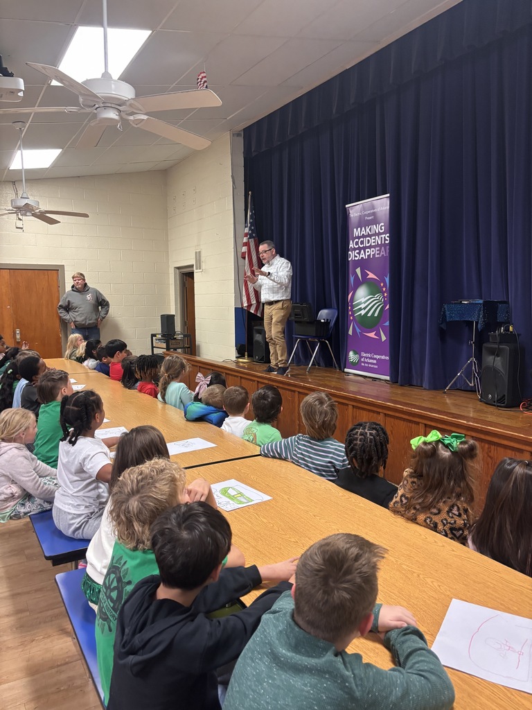 Scott Davis in front our Lawson Students explaining what his show is all about (electrical safety). He is on stage with a banner behind him that reads "making accidents disappear".