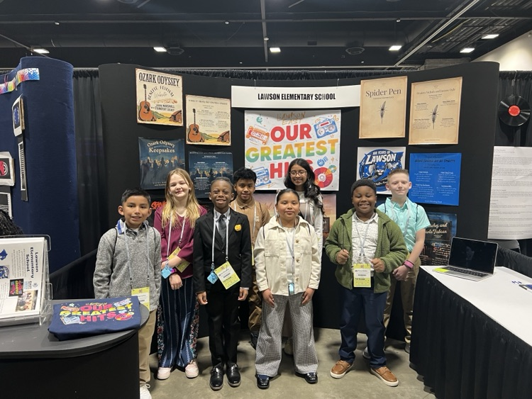 image of EAST conference team wearing business clothing in front of their display. 