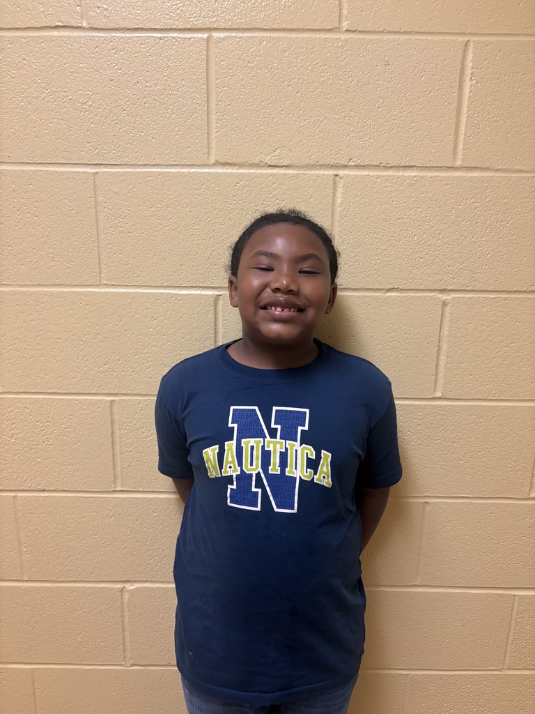 Image of First Grade Student who was nominated for Student of the Month. He is wearing a blue Nautica t shirt. 