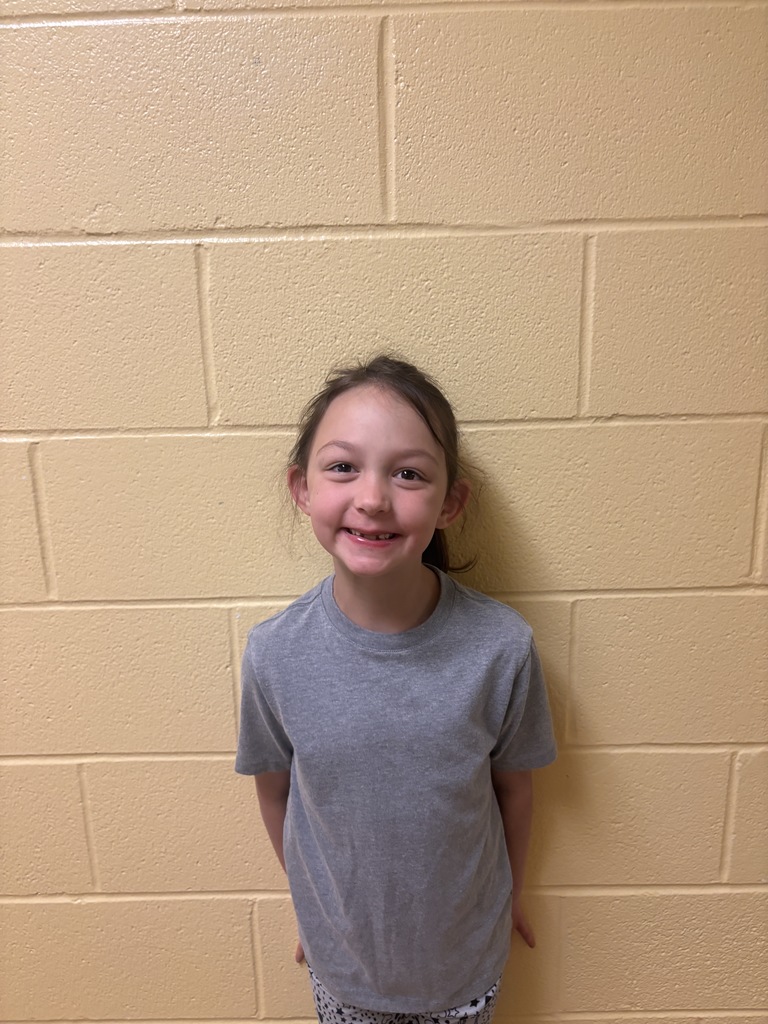 Image of First Grade Student who was nominated for Student of the Month. She is wearing a grey t shirt. 