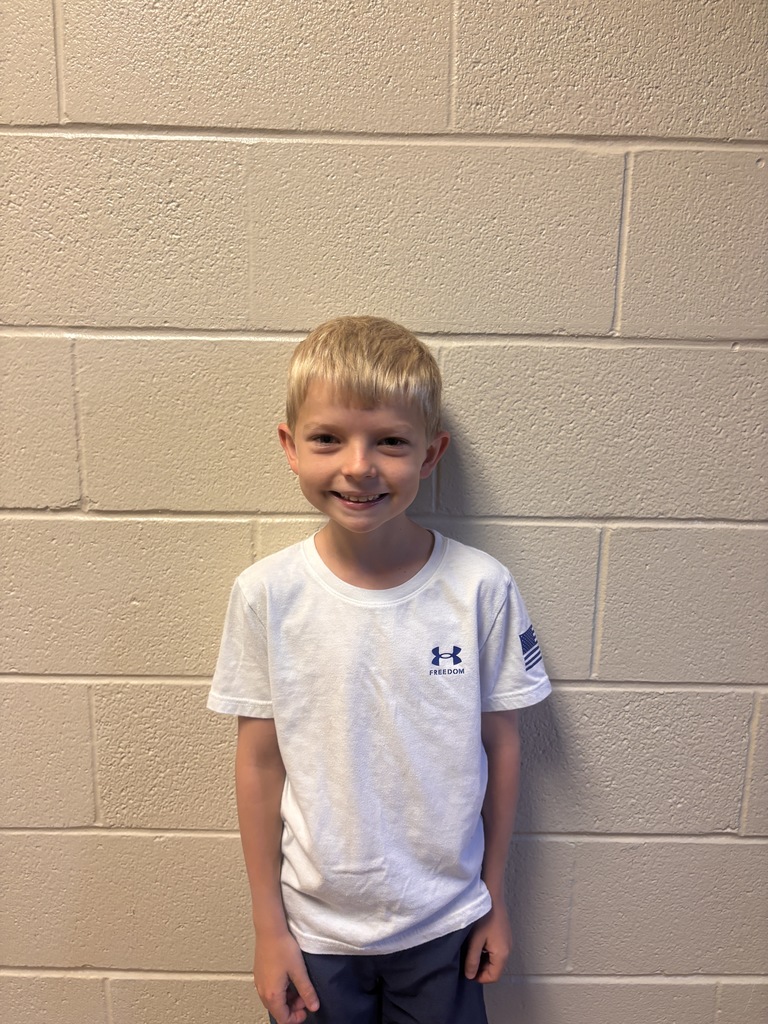 Image of Second Grade Student who was nominated for Student of the Month. He is wearing a white t shirt. 