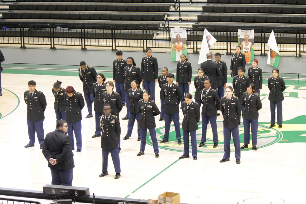 "A wide view of dozens of Mills University Studies High School JROTC cadets standing in strict formation on the basketball court inside Cooper Arena during their JPA inspection."