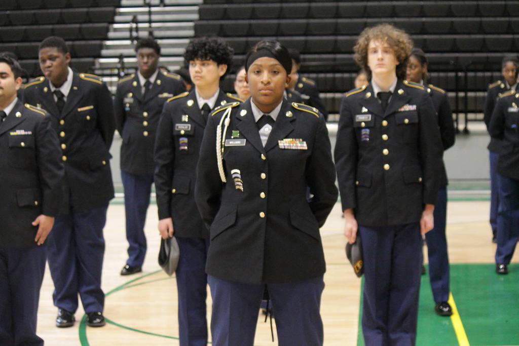 Mills University Studies High School JROTC cadets holding their caps and standing proudly at attention in their dark blue uniforms during their 2026 JPA inspection.