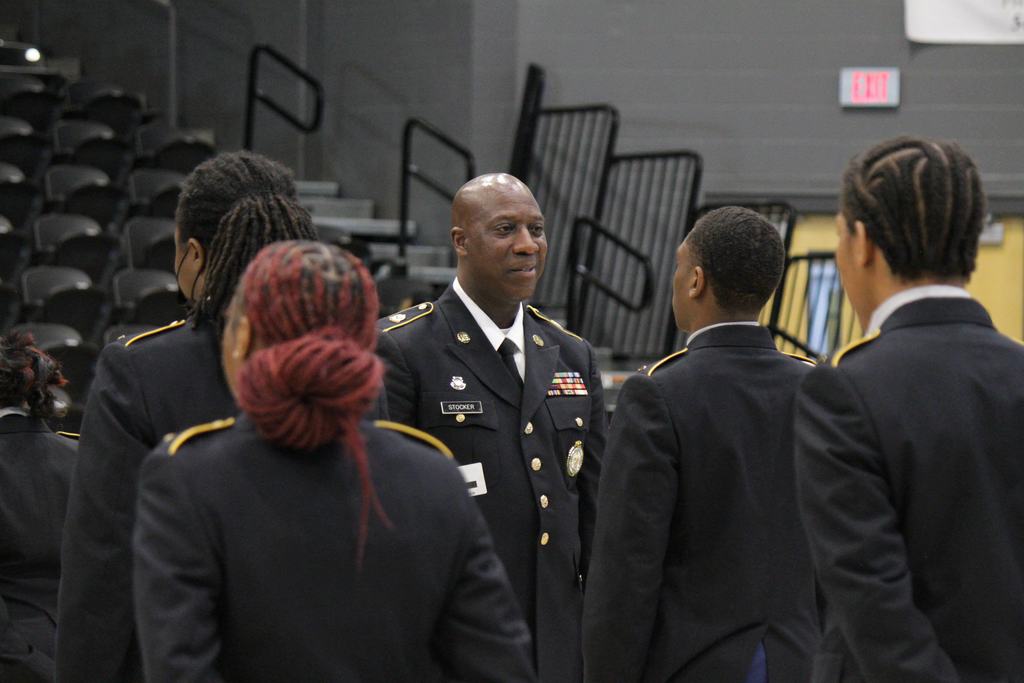 A Master Sergeant instructor speaking with Mills High School JROTC cadets during their formal accreditation inspection in Cooper Arena.