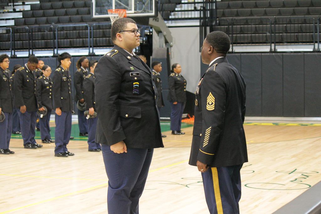A Master Sergeant instructor speaking with Mills High School JROTC cadets during their formal accreditation inspection in Cooper Arena.