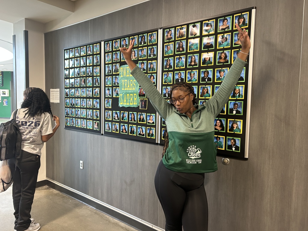 Student posing in front of her senior portrait