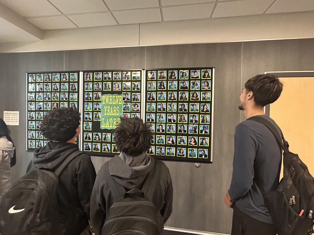 Students looking for their senior portraits on the wall