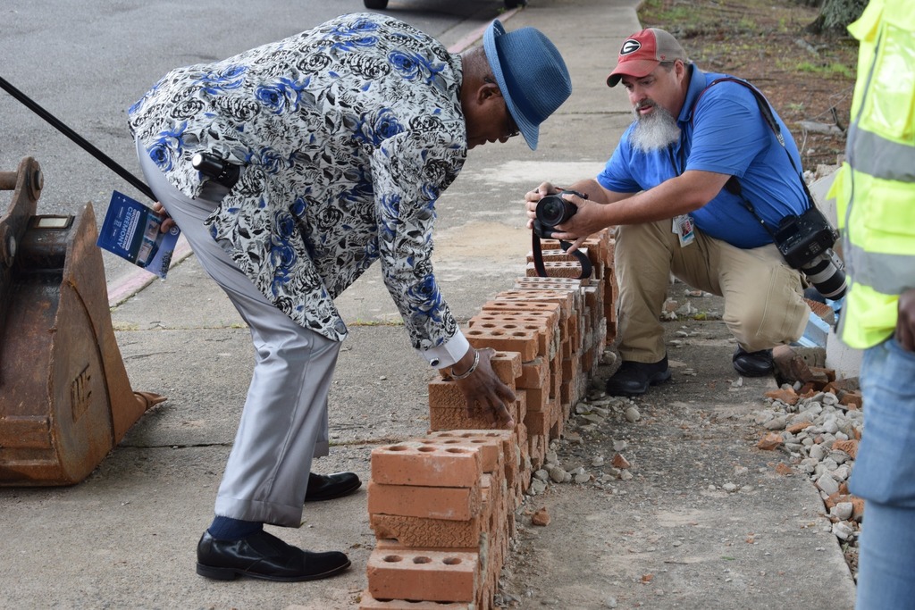 A person picking up bricks off the ground.