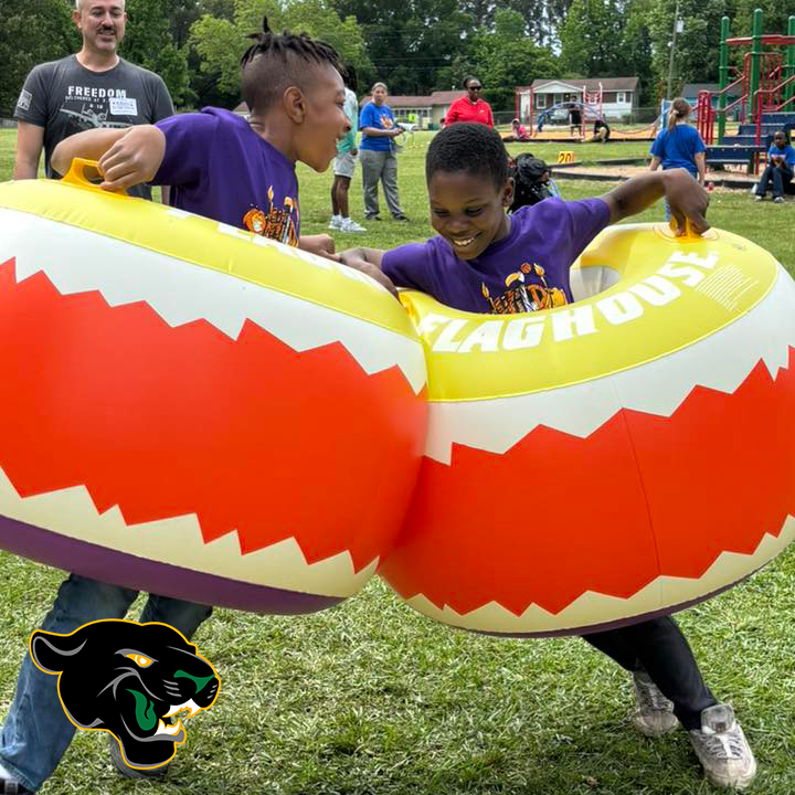 Two students having fun during a field day. Harris Elementary logo is present.