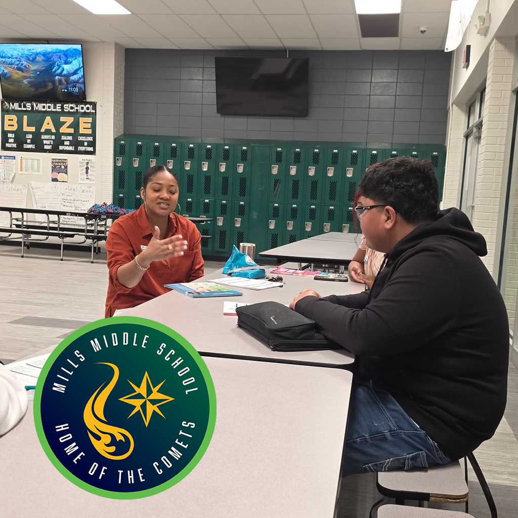 Students learning in a cafeteria. It has Mills Middle School's logo