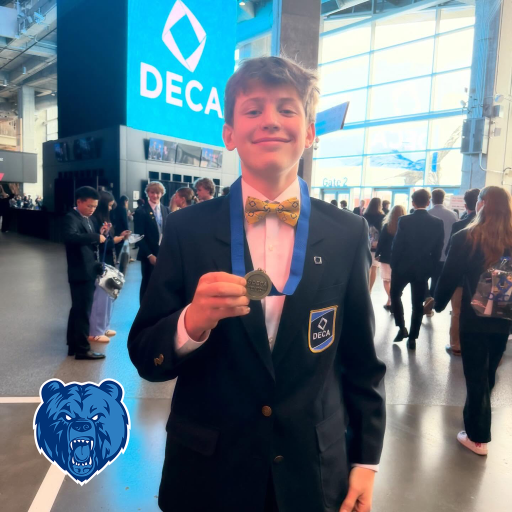 A Sylvan Hills High School student holding a DECA medal.