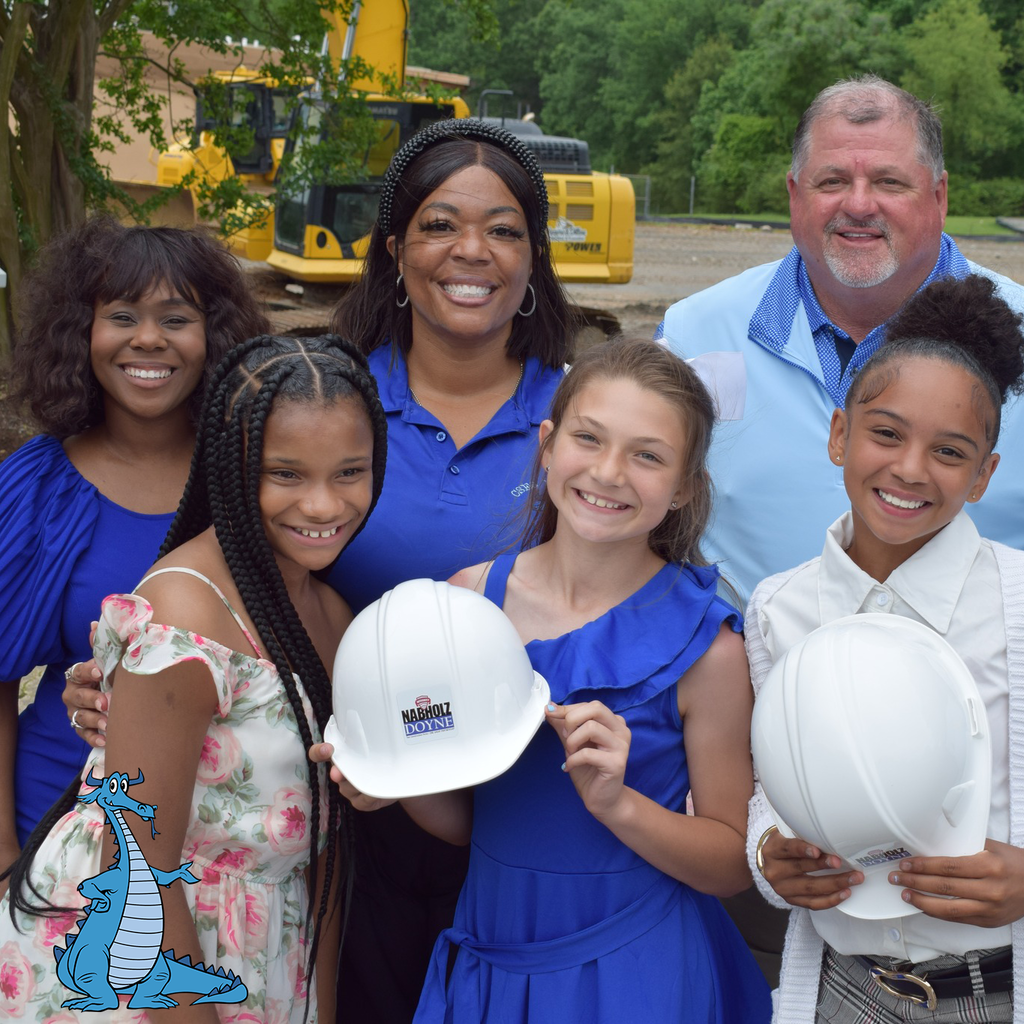 A group picture of students and adults wearing blue. Some are holding hard hats. College Station Elementary logo is present.
