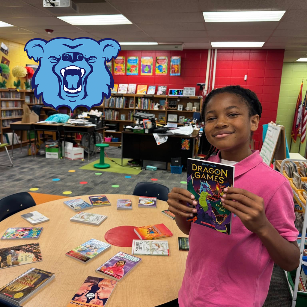 Student holding a book in a colorful school library.