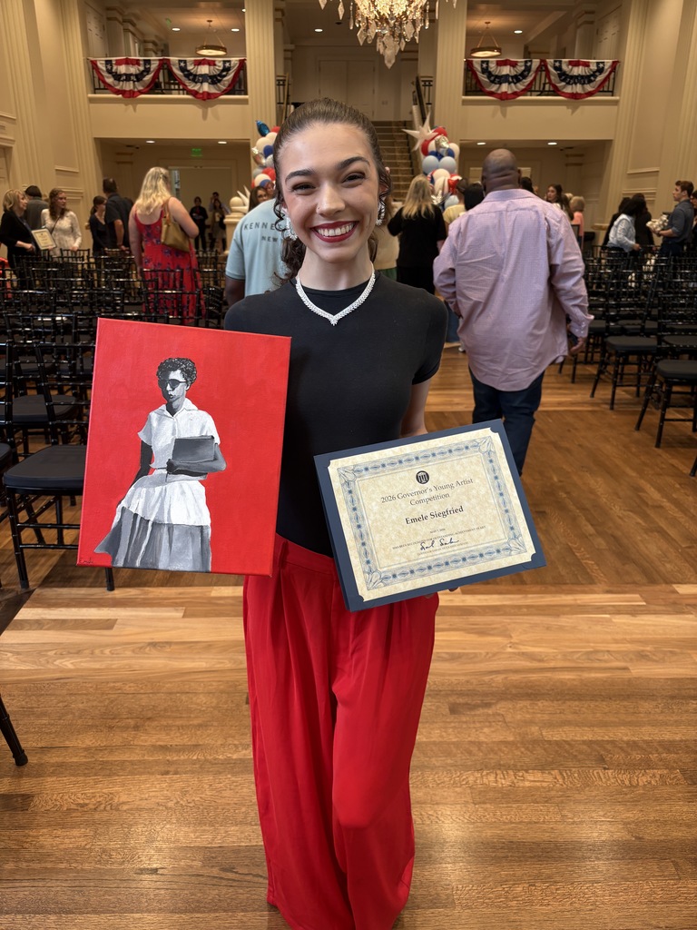 A student stands in a decorated hall holding a certificate and a painting. The painting is a monochrome portrait of Elizabeth Eckford of the Little Rock Nine against a red background. Rows of chairs and patriotic bunting are visible behind the student.