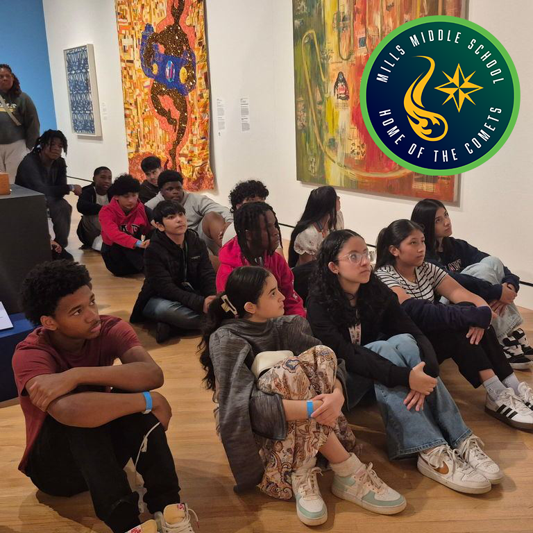 Middle school students sit on the floor of an art gallery facing large abstract artworks during a guided lesson.