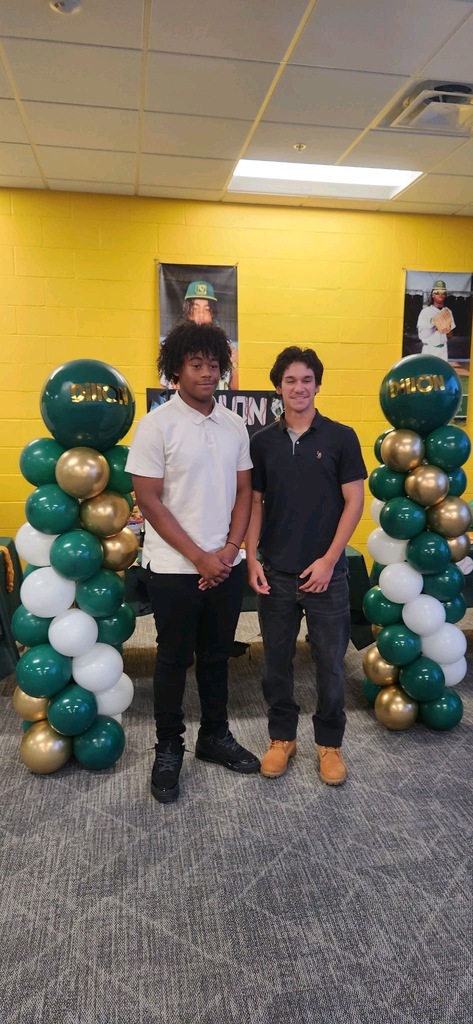 Two students smiling at each other in front of celebration table