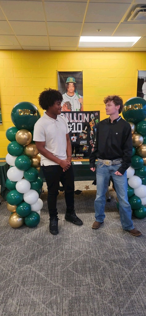 Two students smiling at each other in front of celebration table