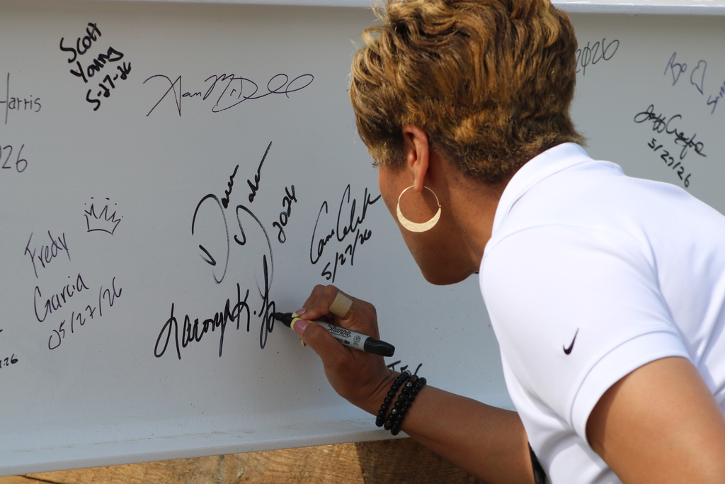 Joe T. Robinson High School Principal Laconya Isaac signs the ceremonial steel beam before it is lifted into place.