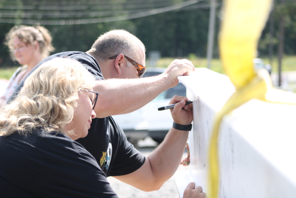 Attendees sign the ceremonial steel beam during the Joe T. Robinson High School topping out ceremony.