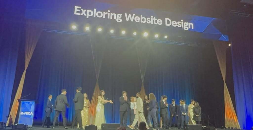 A stage with people for a "Exploring Website Design" awards ceremony