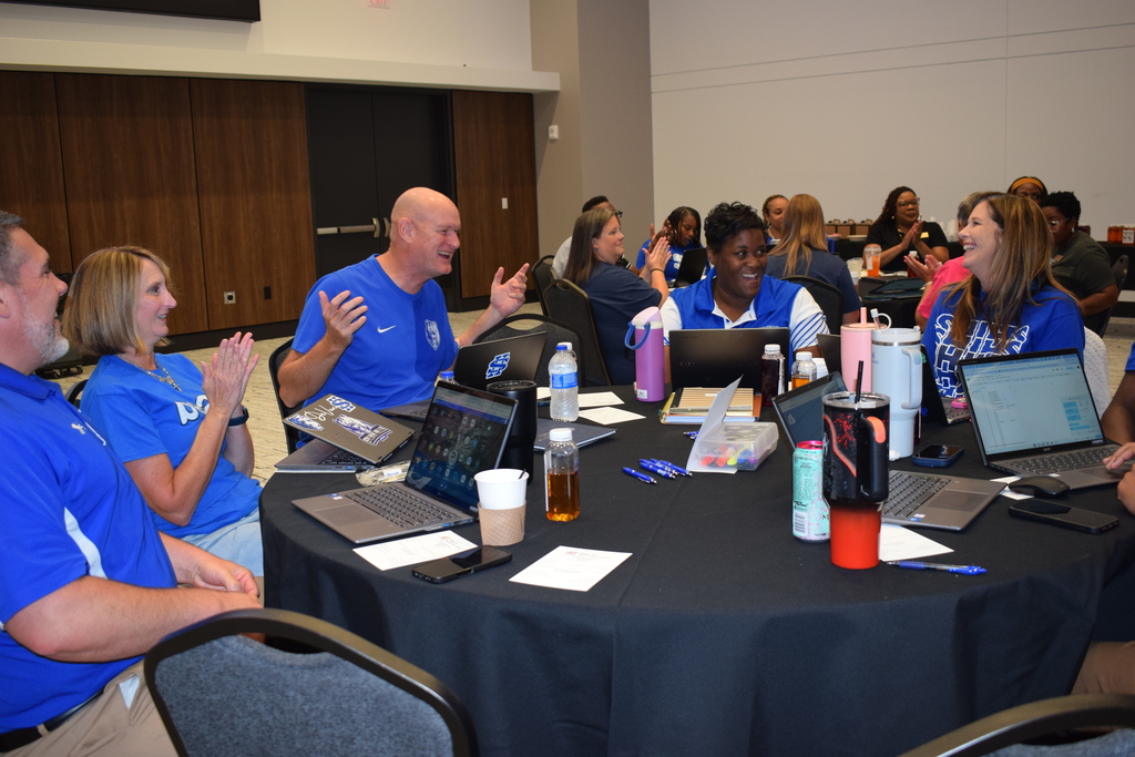 People smiling and talking ar round table