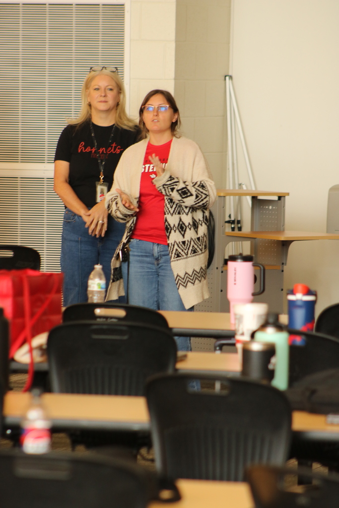 Staff at Maumelle High School stand in a circle during a professional‑development activity, taking turns introducing themselves and sharing something they enjoy.