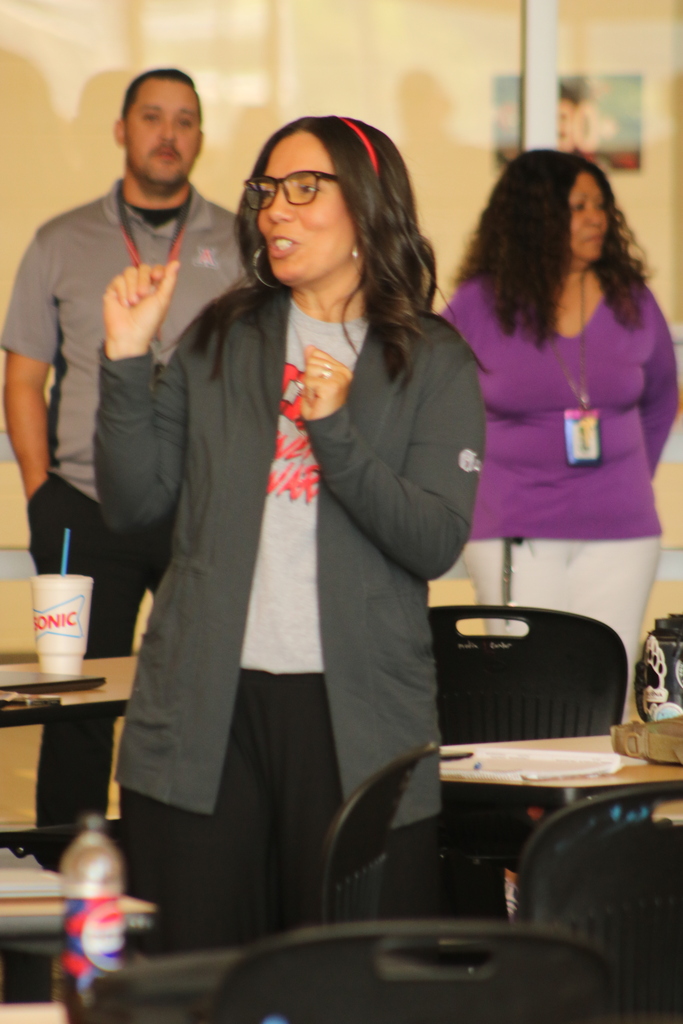 Staff at Maumelle High School stand in a circle during a professional‑development activity, taking turns introducing themselves and sharing something they enjoy.