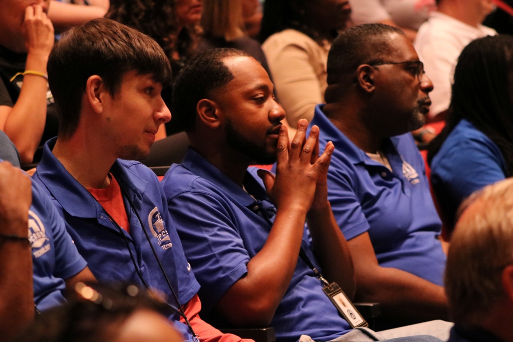 a row of focused people in matching blue