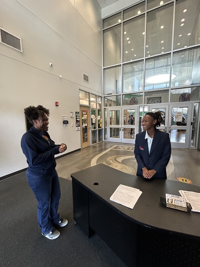 Students at front desk talking to each other