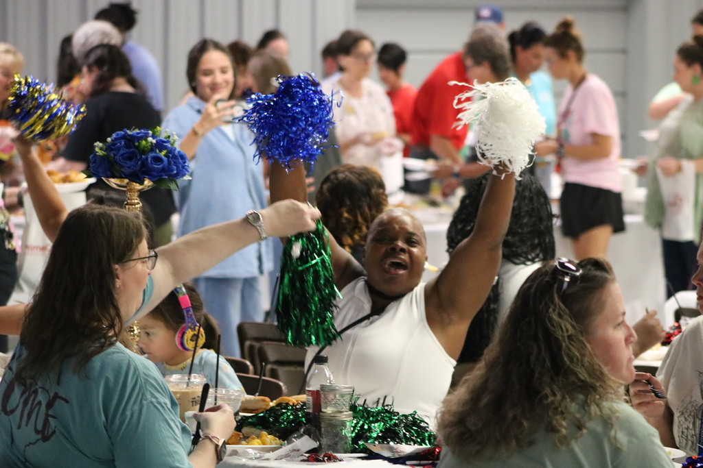 A crowd cheering with pom poms.