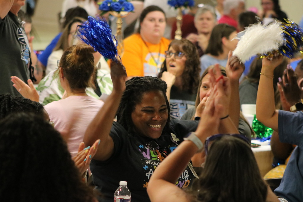 A very excited woman waving pom poms