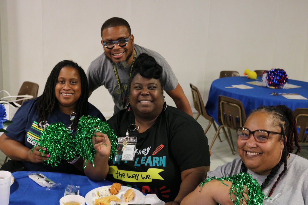 a group of people smiling at a table with food