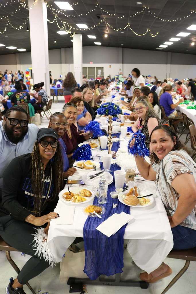 A view down a table of people smiling and eating