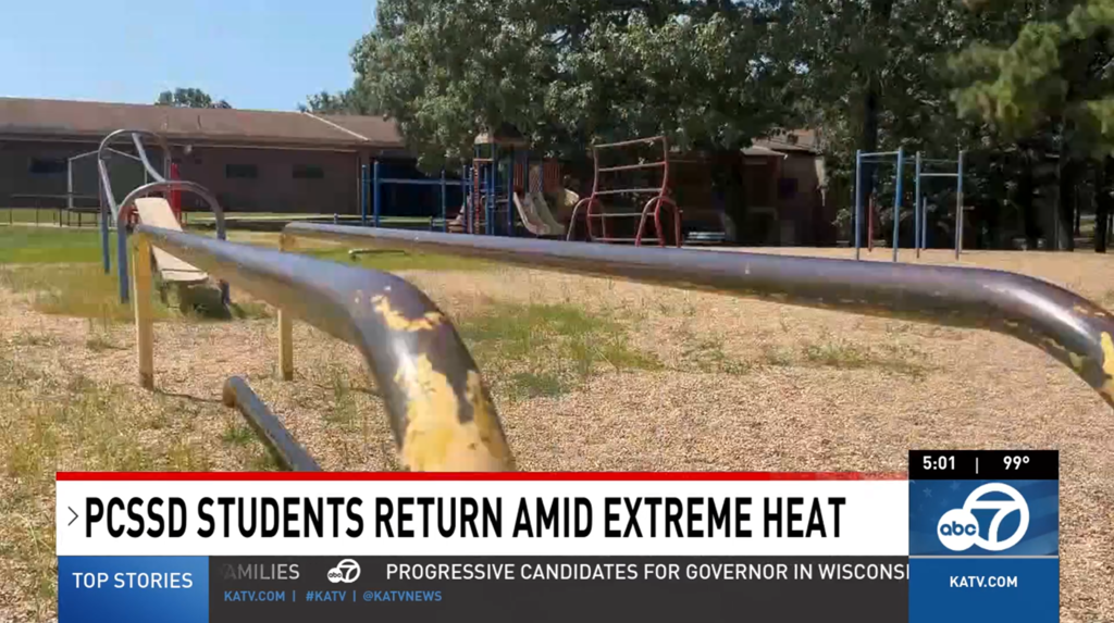 Outdoor school playground equipment with swing sets and slides, students returning to school amid hot weather conditions.