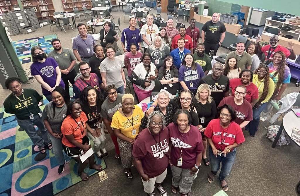 A photo of a crowd of educators looking upward and smiling with their college and career shirts on.