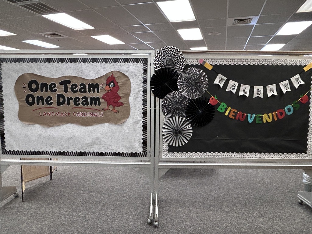 Decorative bulletin board with text "One Team One Dream" and "Bienvenido" along with patterned paper fans and other decorations.