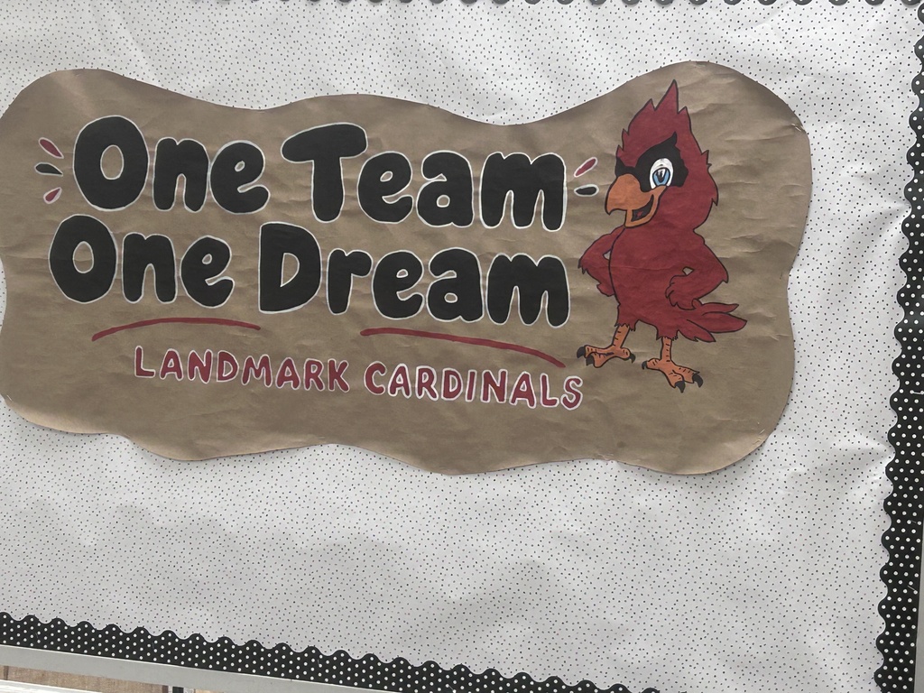 Cardboard sign with text "One Team One Dream" and a cardinal bird logo, representing the Landmark Cardinals.