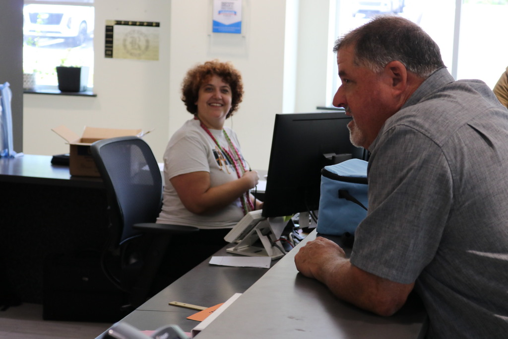 a man speaking to a front desk worker