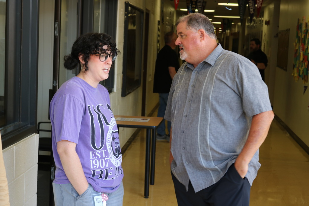 Two people talking in a hallway