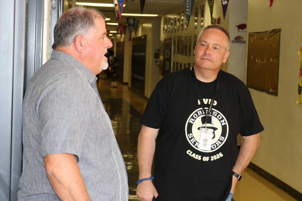 Two men talking in a hallway