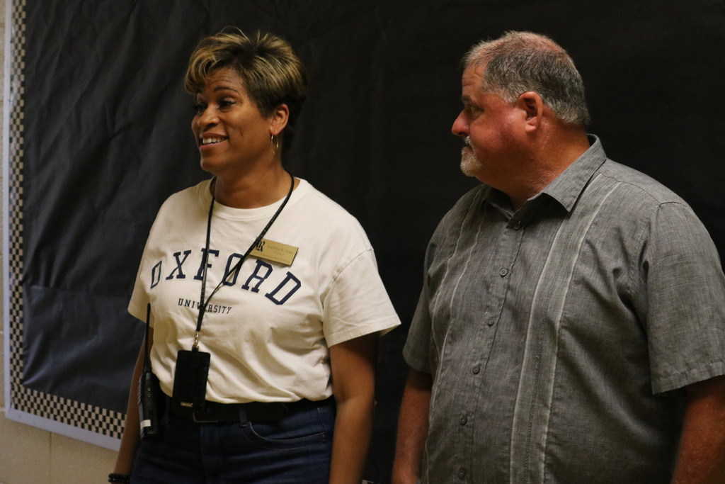 A man and a woman smiling in a hallway