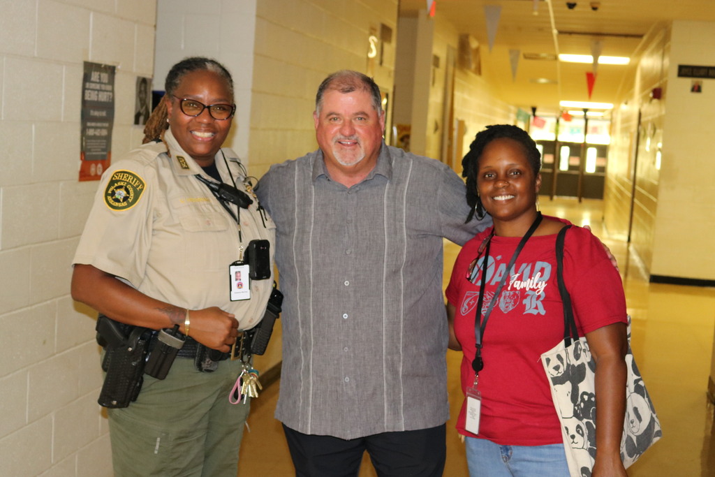 Three people smiling. One is in sheriff's office uniform