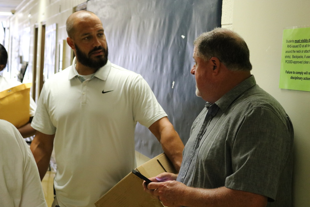 Two men talking in a hallway